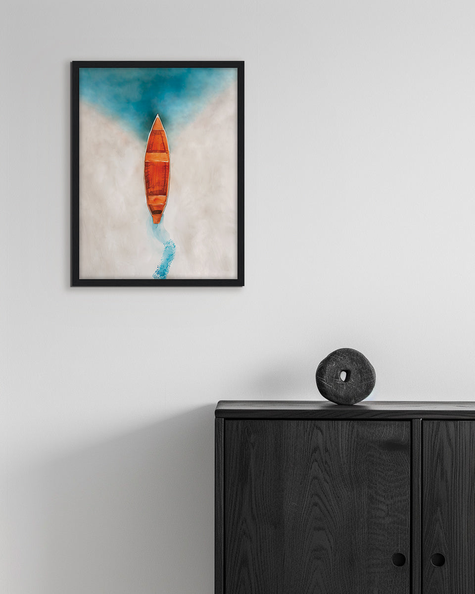 Wall art of an orange wooden boat on a beach about to enter the blue water