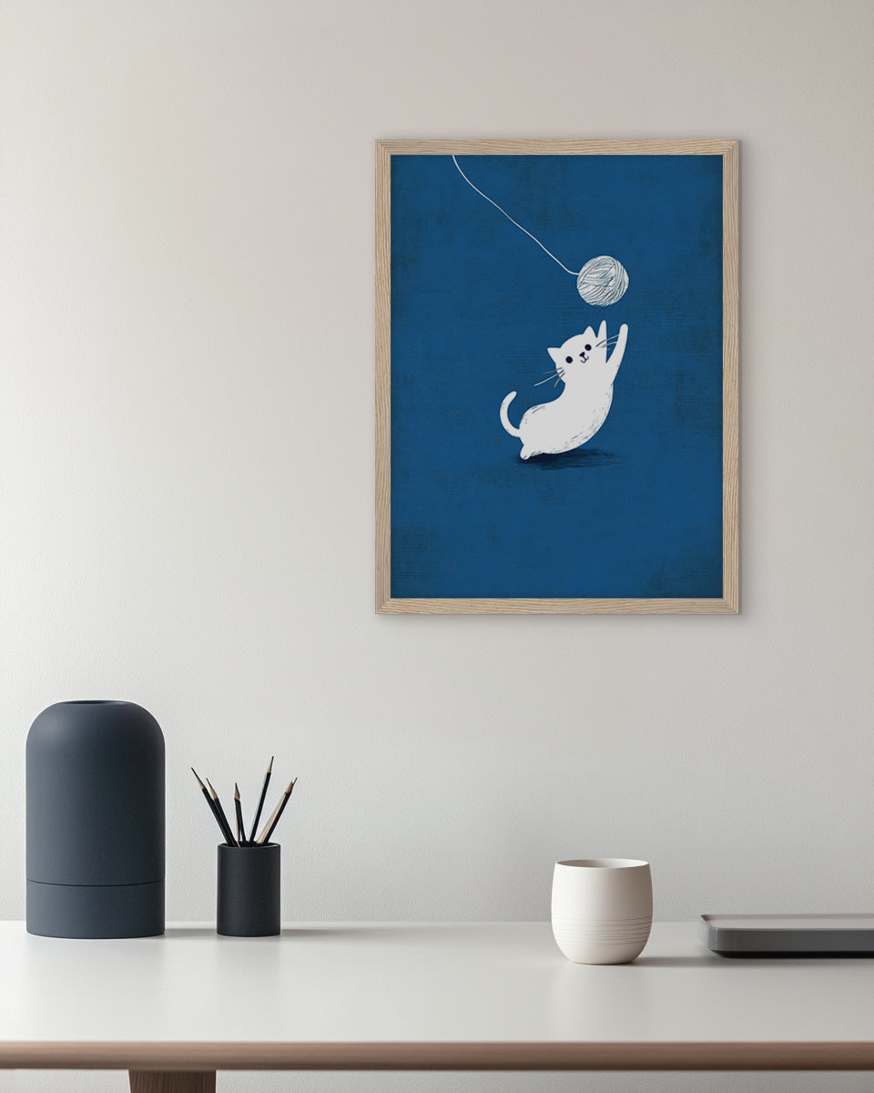 Wall art illustration of a white cat playing with a ball of yarn on a blue background
